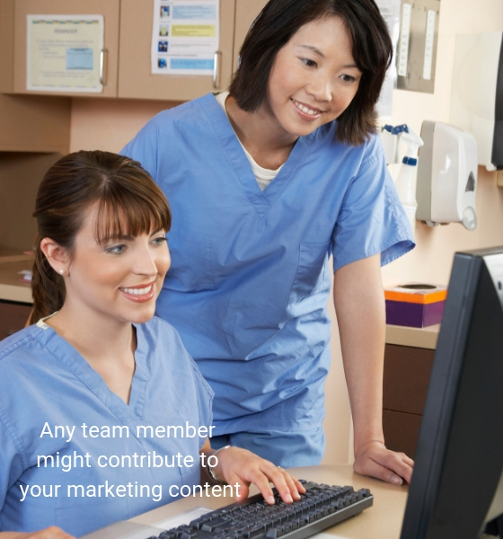 Photo of two technicians contributing to content at a computer